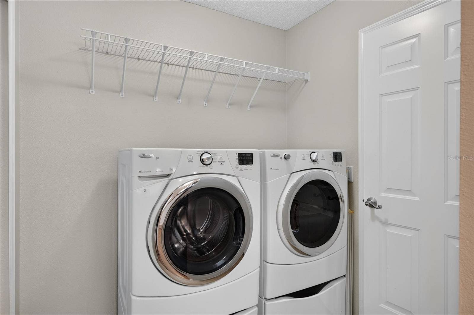 INDOOR LAUNDRY - Adjacent to the kitchen and features a front-load WASHER & DRYER with a storage shelf above the appliances. Note door (R) provides direct access to the 1.5 CAR GARAGE.