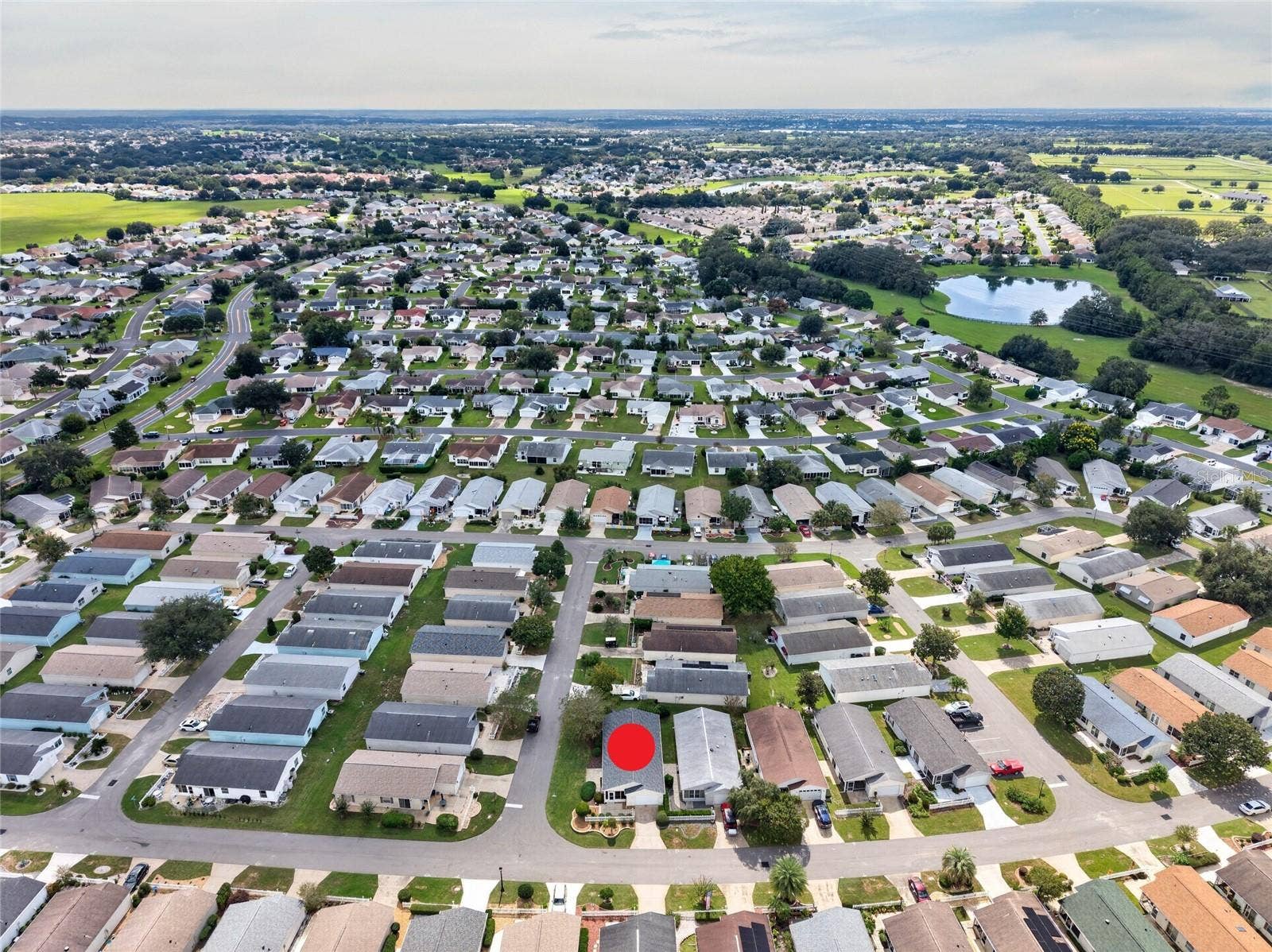 AERIAL  Looking South  CORNER LOT villa (marked) in SANTO DOMINGO, with Cazares Avenue (left), the Sharon L. Morse Owl Preserve (deep left) and golf-cart access to Lake Sumter Landing (deep center).
