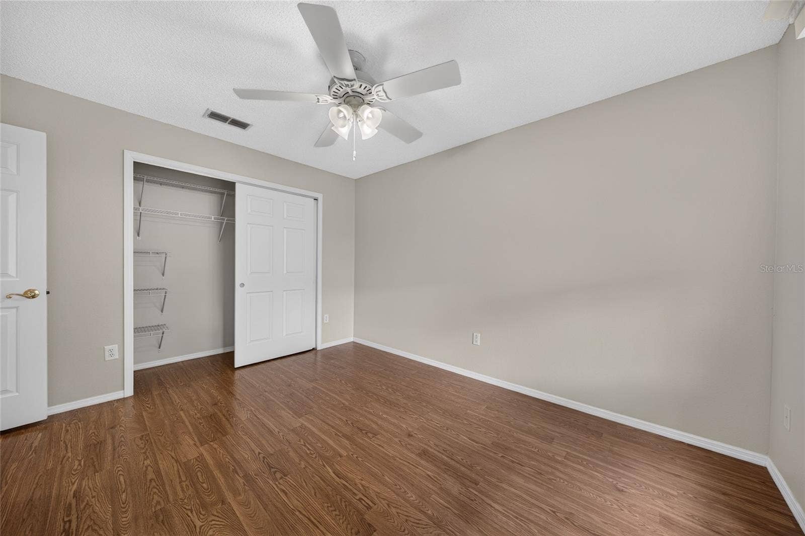BEDROOM #2 - Open closet view reveals shelving and hanging space behind the double closet doors.
