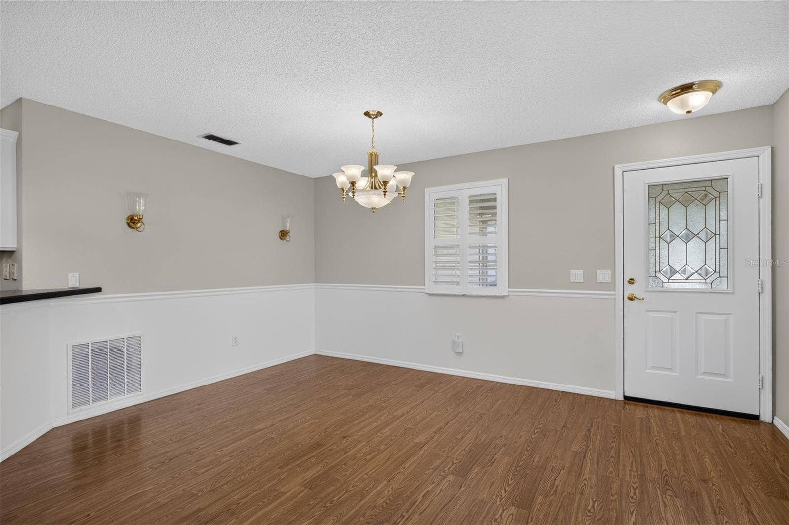 Close up view of DINING AREA - Alternate angle showing the chair rail and back of FRONT DOOR w/ half-lite decorative glass insert.