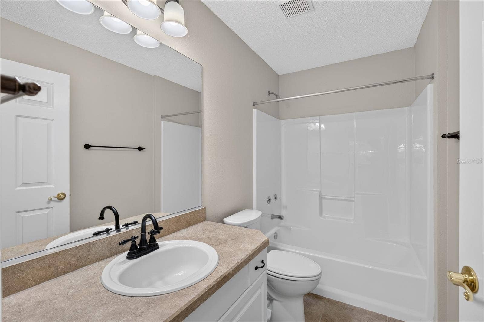 BATHROOM #2 - View of TUB/SHOWER COMBO, comfort-height toilet and single-sink vanity with mirror.