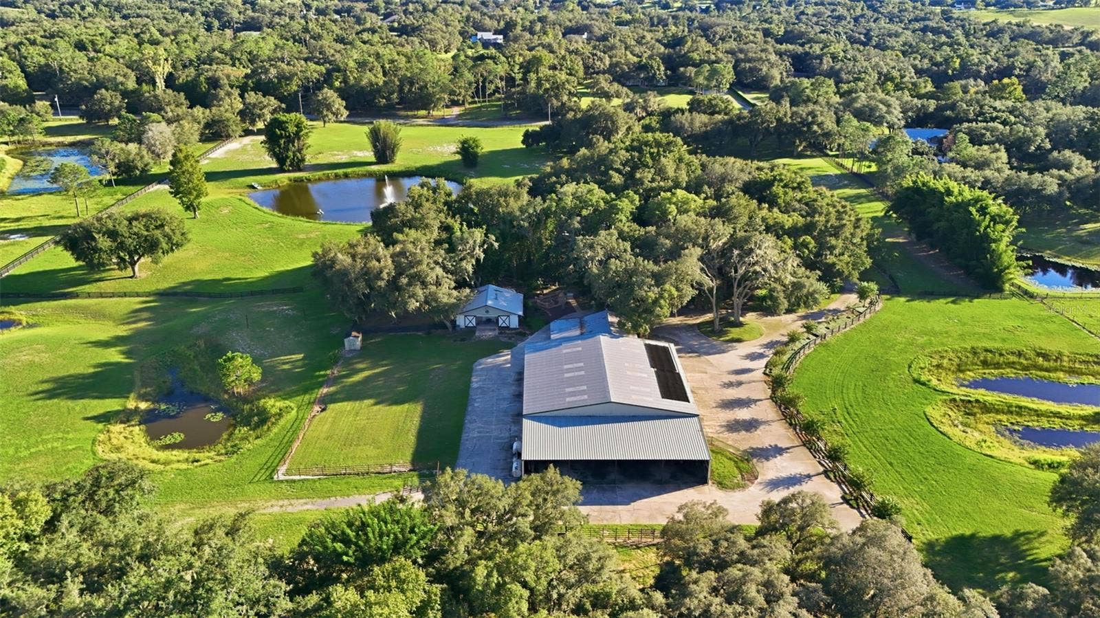 15211 VINOLA PLACE, Montverde, FL 34756 aerial of property, horse barn and front pond with fountain