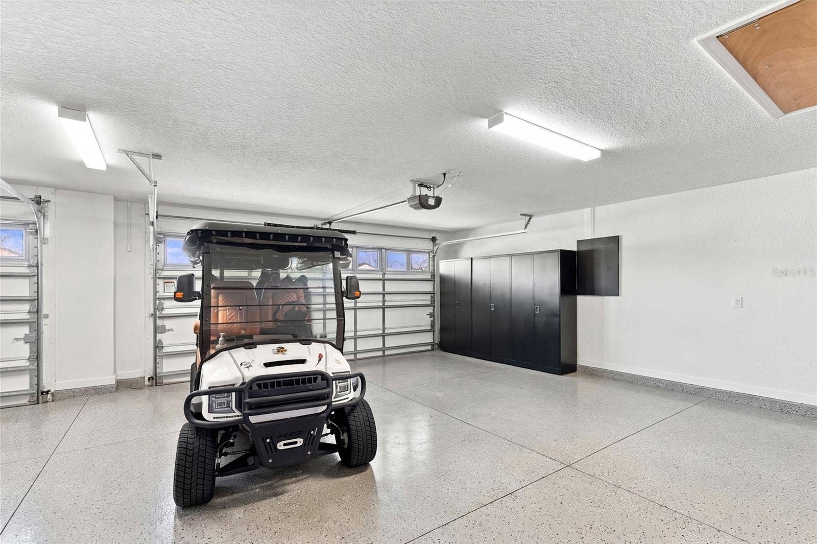 614 LAKE CREEK CIRCLE, The Villages, FL 34762 Garage's 2 Car area with a glimpse of Golf Cart side to left