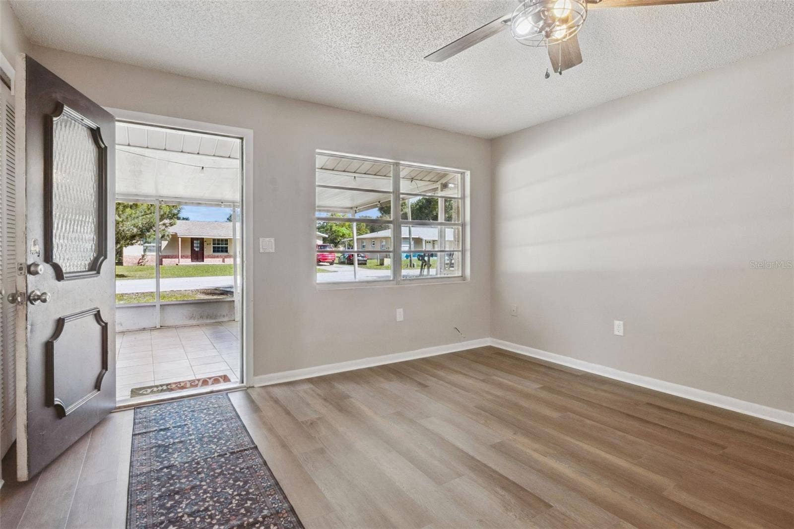 416 WINNERS CIRCLE, Lady Lake, FL 32159 Living Room with ceiling fan and vinyl flooring.