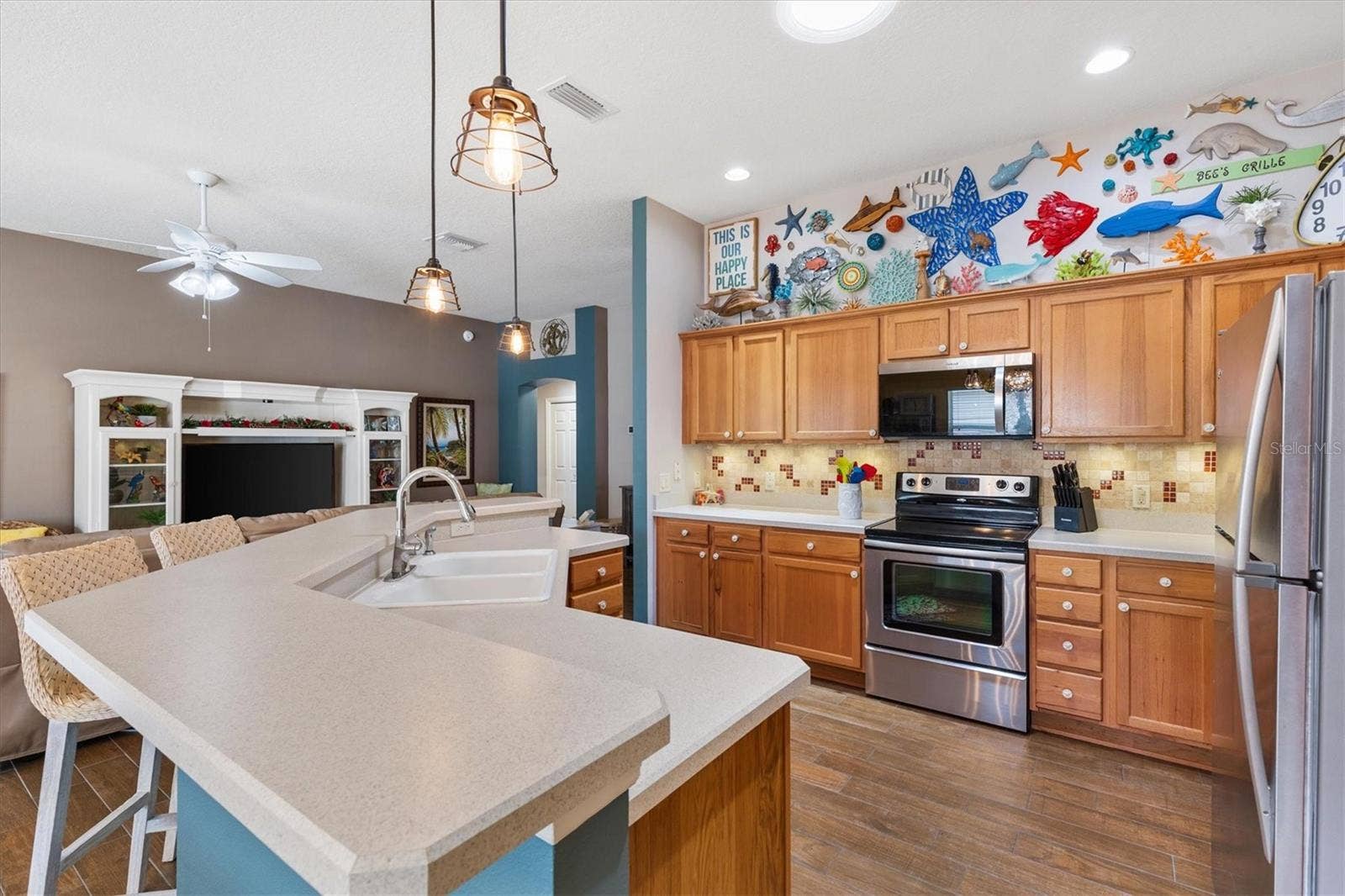 2398 FLATWOOD STREET, The Villages, FL 32162 KITCHEN WITH LOTS OF CABINETS AND BAR STOOLS