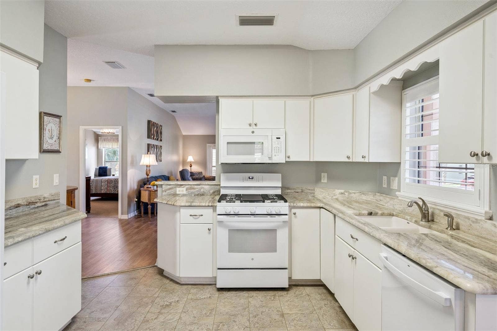4900 CANOE COURT, Tavares, FL 32778 Kitchen with granite counters, white cabinetry and appliances from 2024.