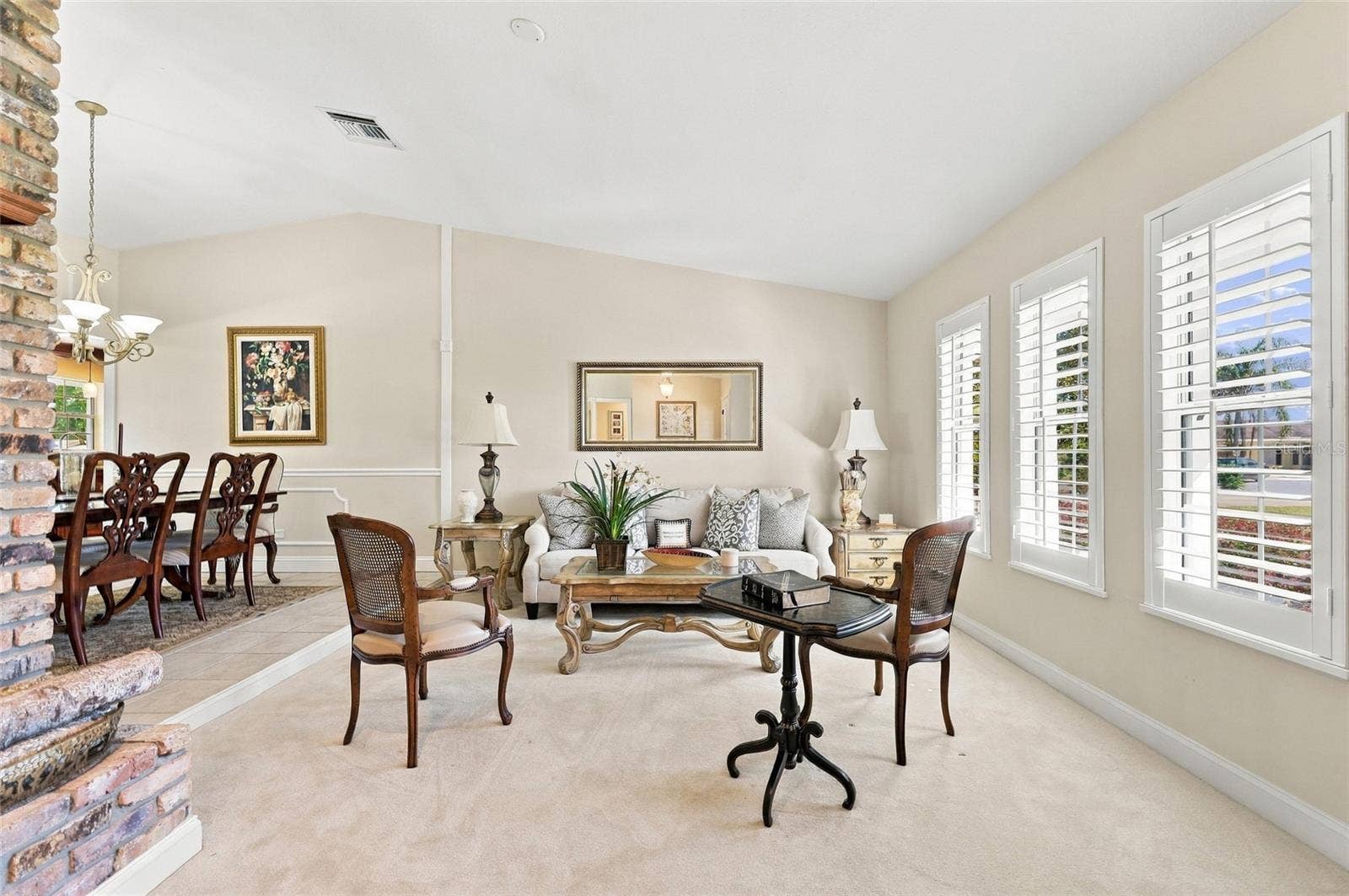 13205 MARIA AVENUE, Clermont, FL 34711 Living Room with plantation shutters & wood burning fireplace