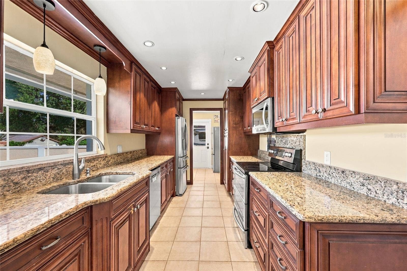 13205 MARIA AVENUE, Clermont, FL 34711 Kitchen with granite counters & view of pool