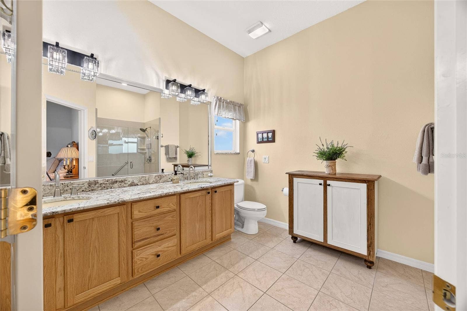 17942 SE 88TH CASCADE COURT, The Villages, FL 32162 The primary bath features a spacious vanity with dual sinks, ample cabinet storage, and a large mirror with overhead lighting.