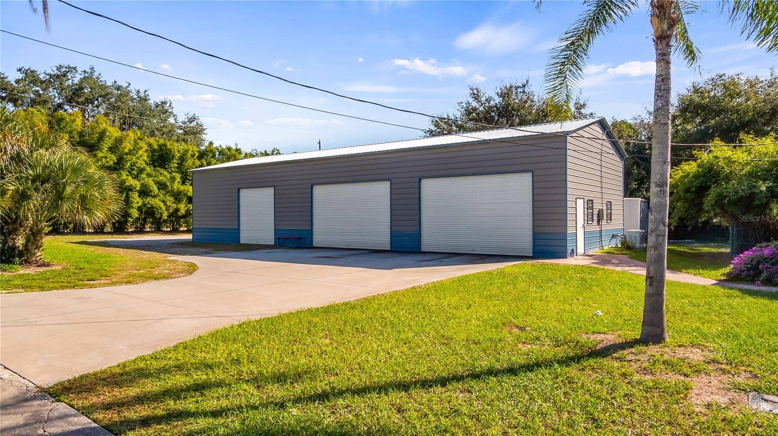 1730 NITA PLACE, Clermont, FL 34711 HUGE 30X75 Metal Building installed in October of 2022, has 6 large bay doors, some have electric openers. The completely paid off solar panels are located on top of this metal building. It basically covers the power bill for the main pool home and this building. The whole home generator is located on the south side of this metal building. It helps to support the main home and this building when Power is out.