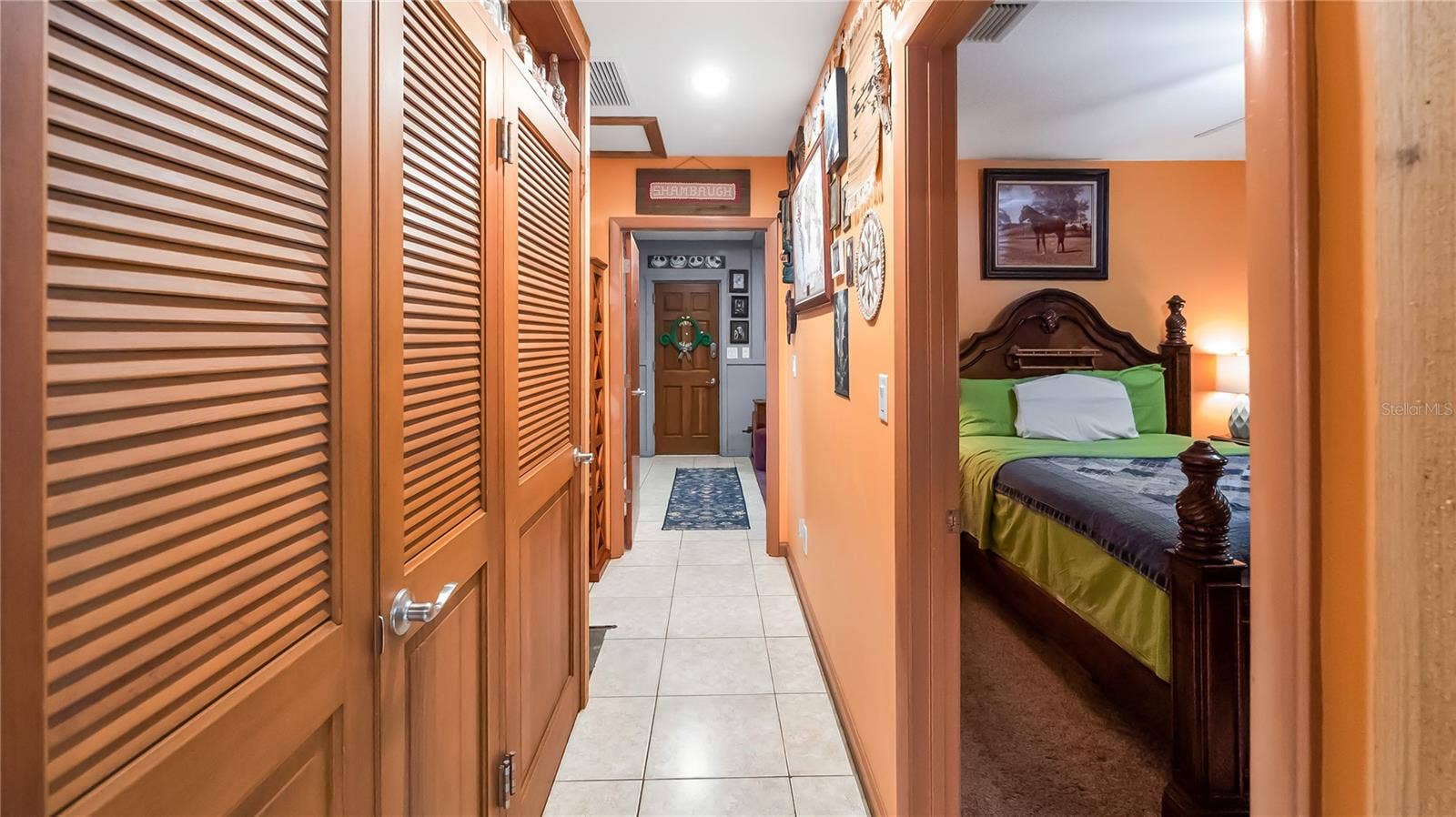1730 NITA PLACE, Clermont, FL 34711 Hall way on guest north side of the main home. Two bedrooms (one being used as TV room, Full bathroom and laundry room. wall of storage closets that lead to an exit door to pool. Easiy access to guest bathroom from pool.