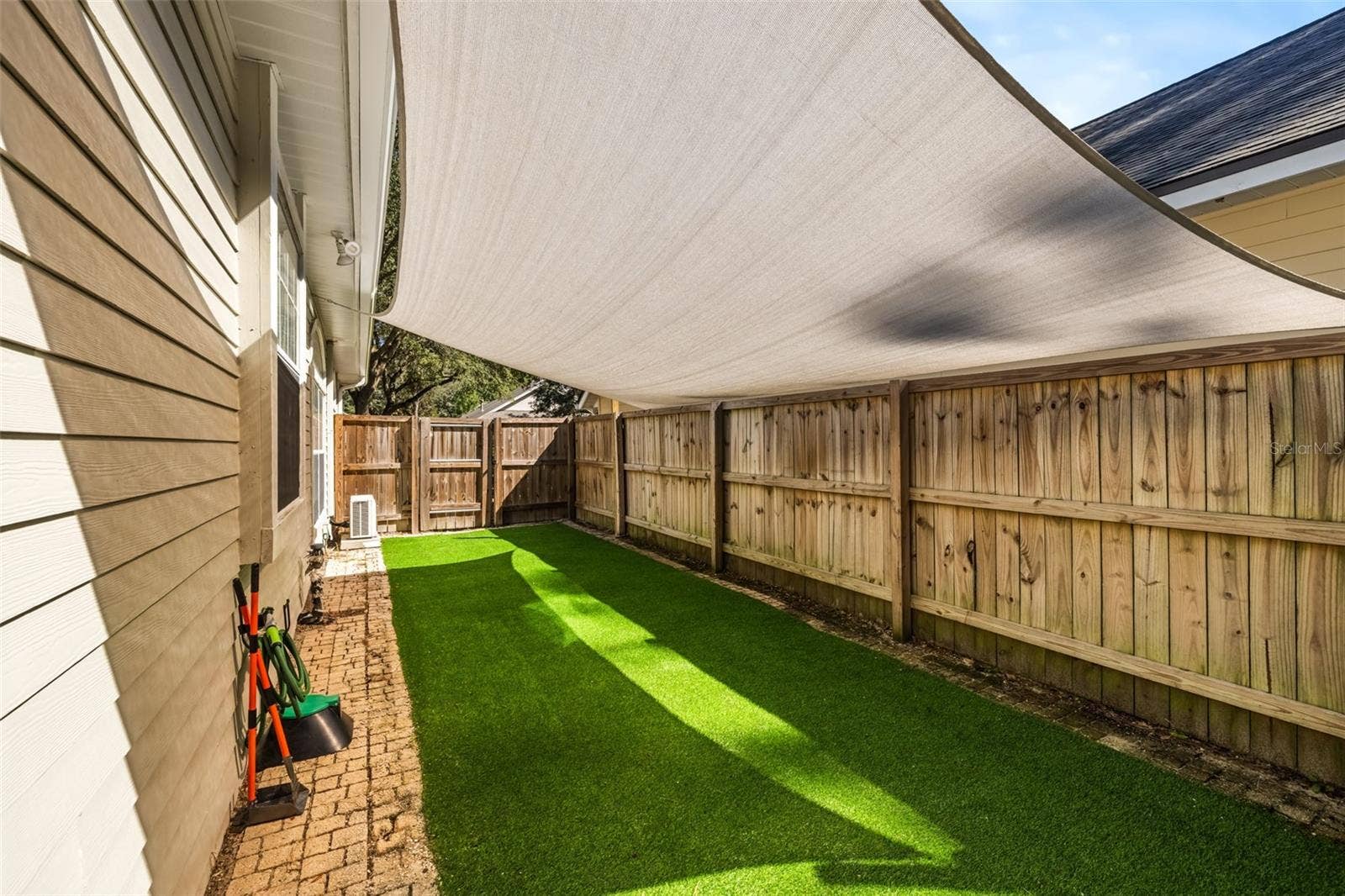Side yard with astroturf and awning.