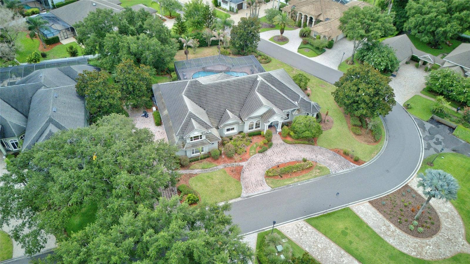 9480 WATERFORD OAKS DRIVE, Winter Haven, FL 33884 Front elevation- circular drive & boat ramp across the street on Lake Winterset, the Chain of Lakes