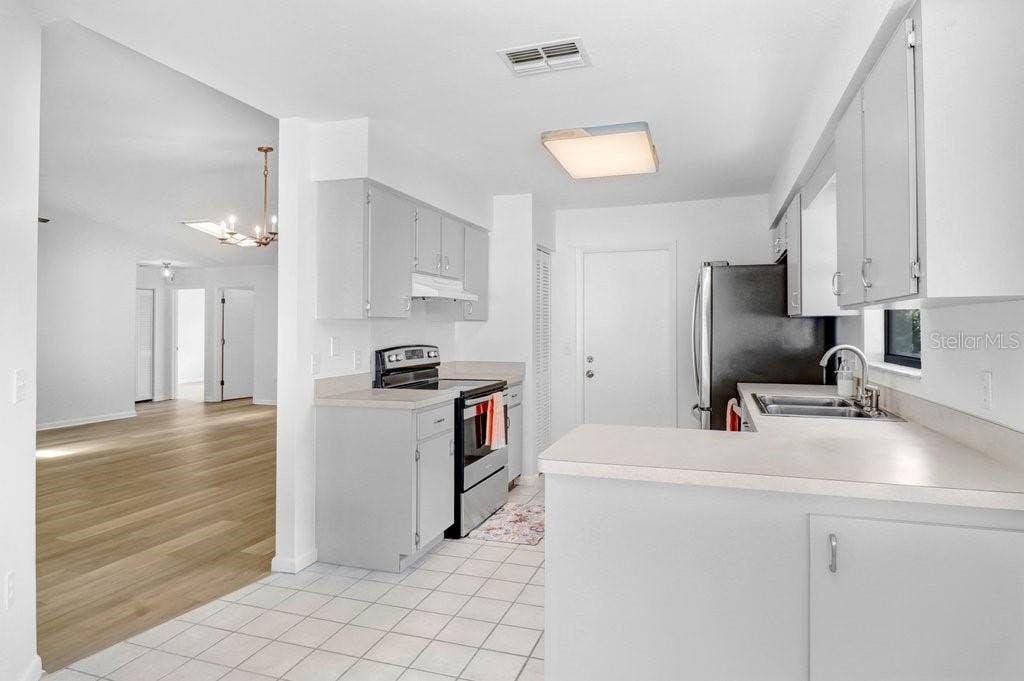 Dinette & Kitchen opens to Living Dining on the left.  Both have  sliding glass doors opening to enclosed patio. Door to the right leads to garage.