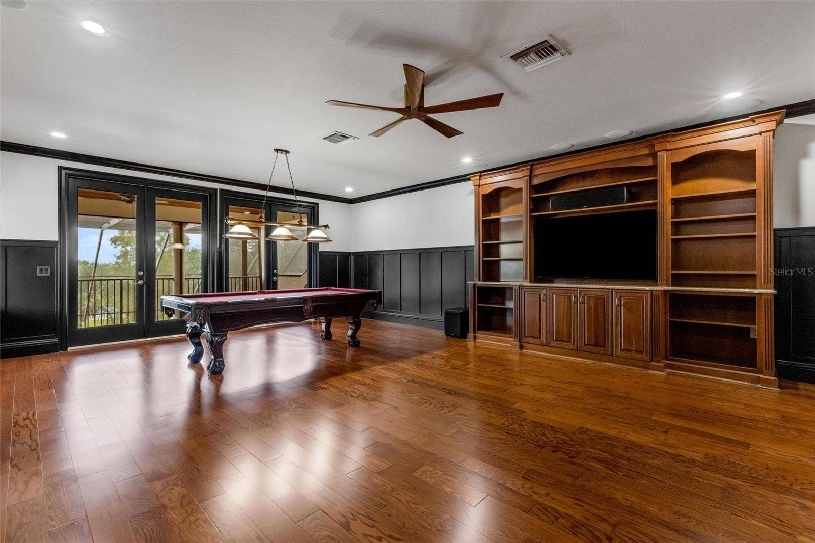 2734 BELLERIVE DRIVE, Lakeland, FL 33803 The built-in entertainment system, custom wainscoting all around and two sets of glass doors that open to the balcony.