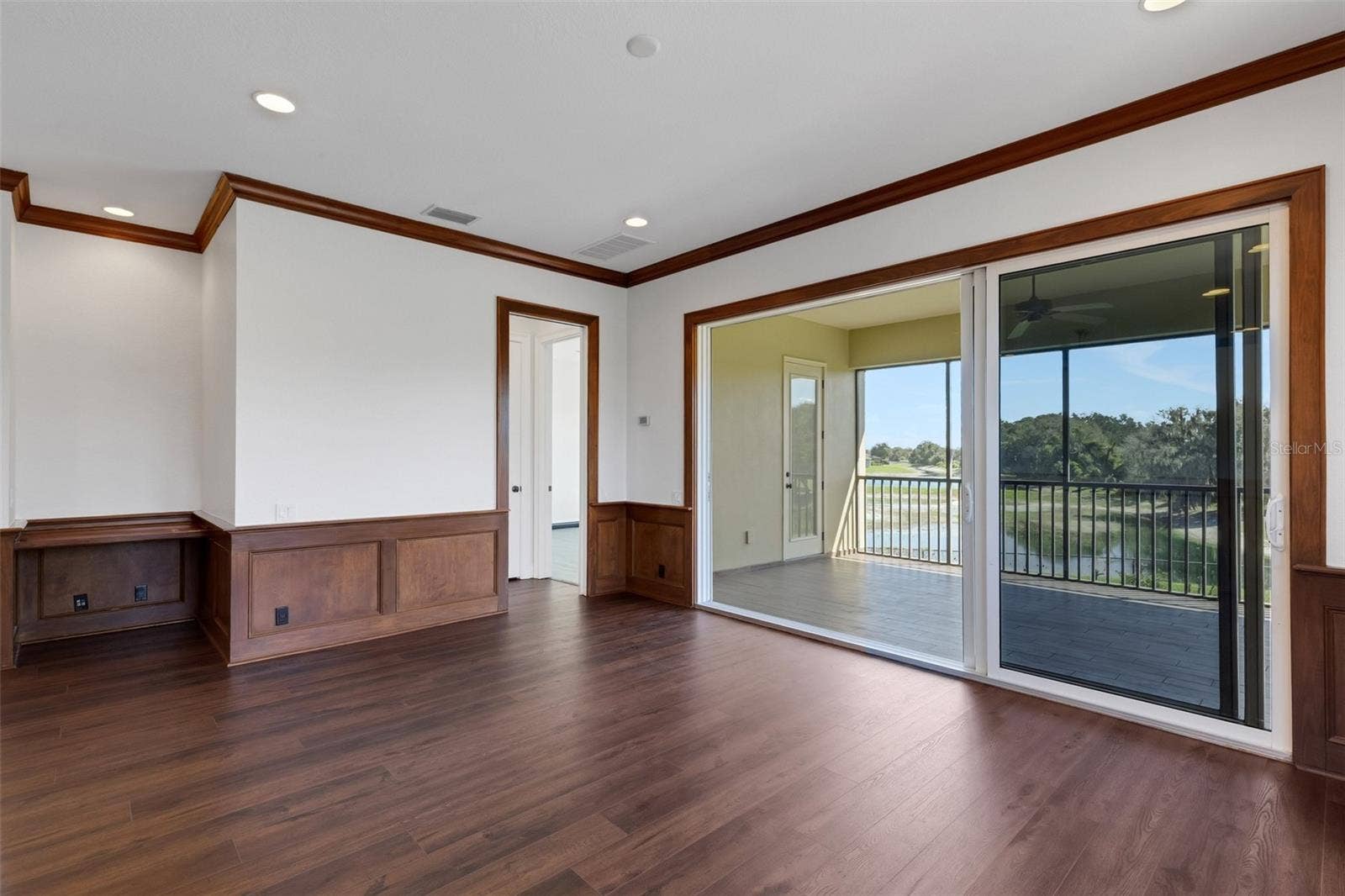 6562 EAGLE VIEW LOOP, Lakeland, FL 33813 With a built-in desk, wood wainscoting accents, large stacking slider that opens to the screen enclosed balcony overlooking the pool area below.
