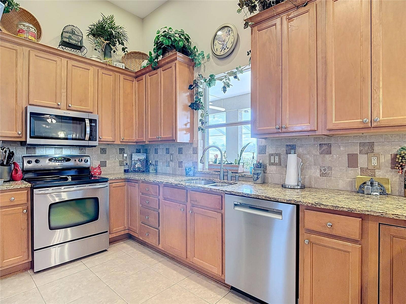 Kitchen features granite counters & wood cabinets