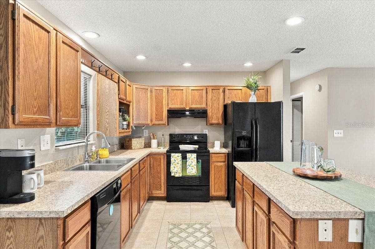 5244 QUIET CREEK LANE, Lakeland, FL 33811 Kitchen features new counter tops, appliances convey and large kitchen island for good workspace.
