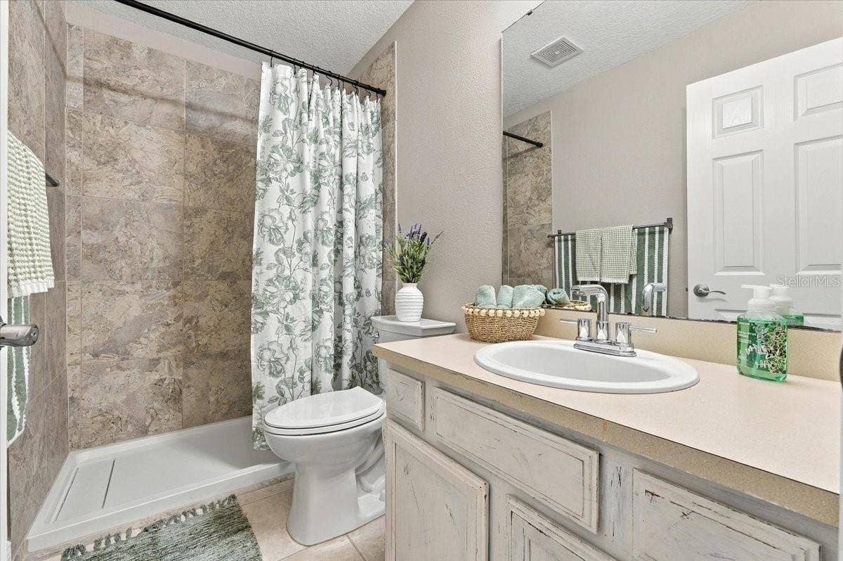 5244 QUIET CREEK LANE, Lakeland, FL 33811 Guest bath with updated shower, new toilet ceramic tile flooring.