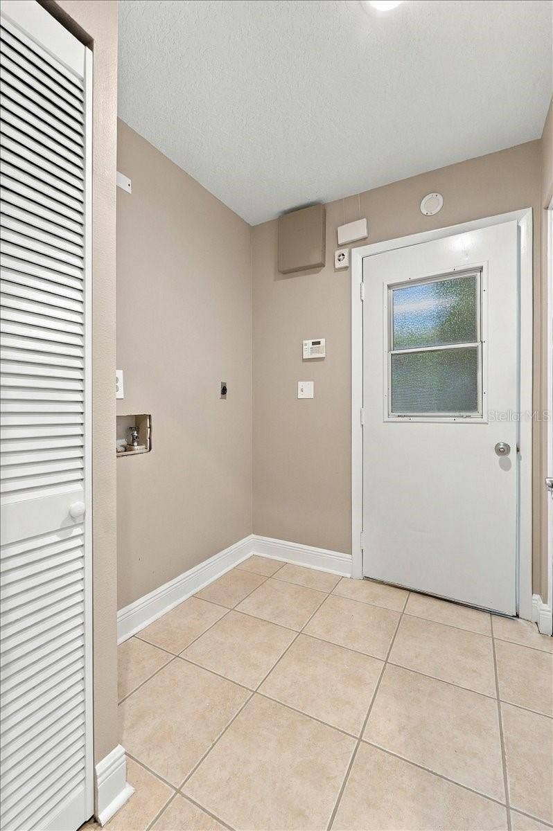 5244 QUIET CREEK LANE, Lakeland, FL 33811 Inside utility room with access to the garage. Electric washer and dryer hook ups.