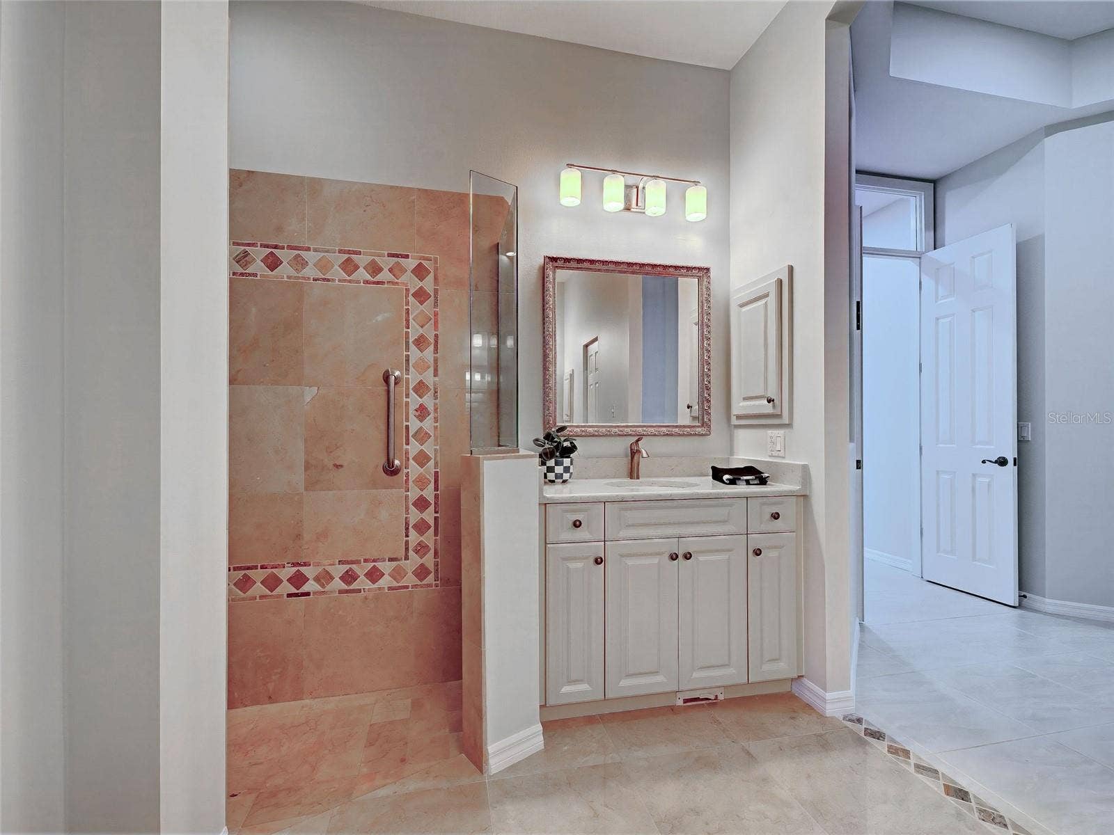 Primary bathroom has plenty of storage space and new light fixtures.