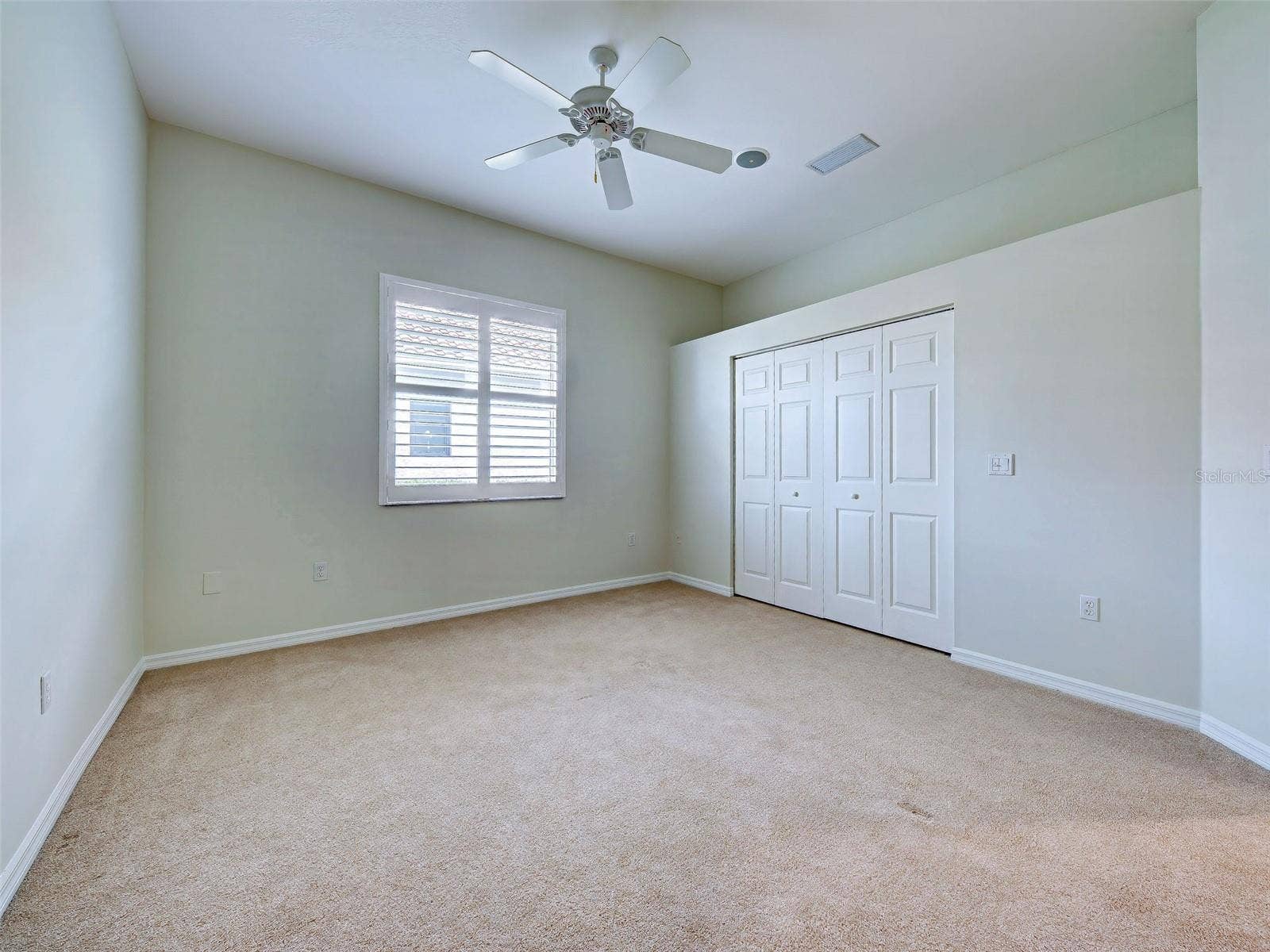 Large, ensuite bedroom with fresh interior paint, plantation shutters, newer carpet and a large closet.