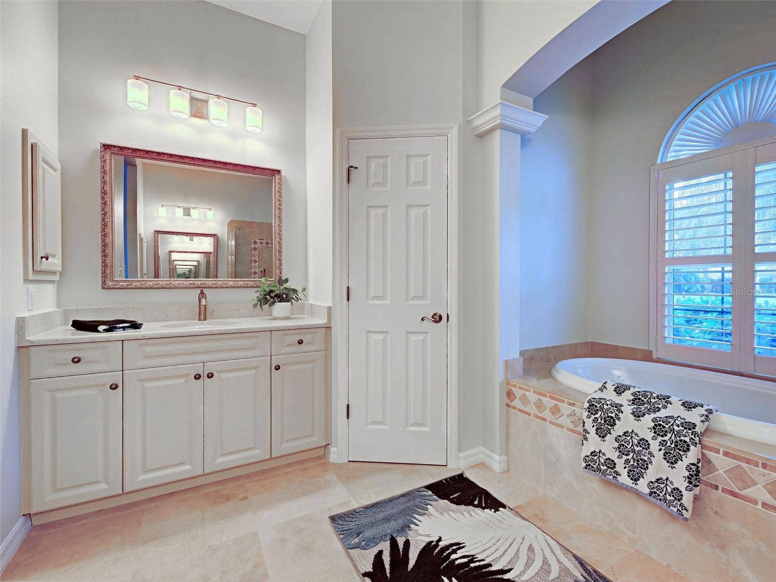 Primary ensuite bathroom features dual, split vanities, private commode and garden tub.