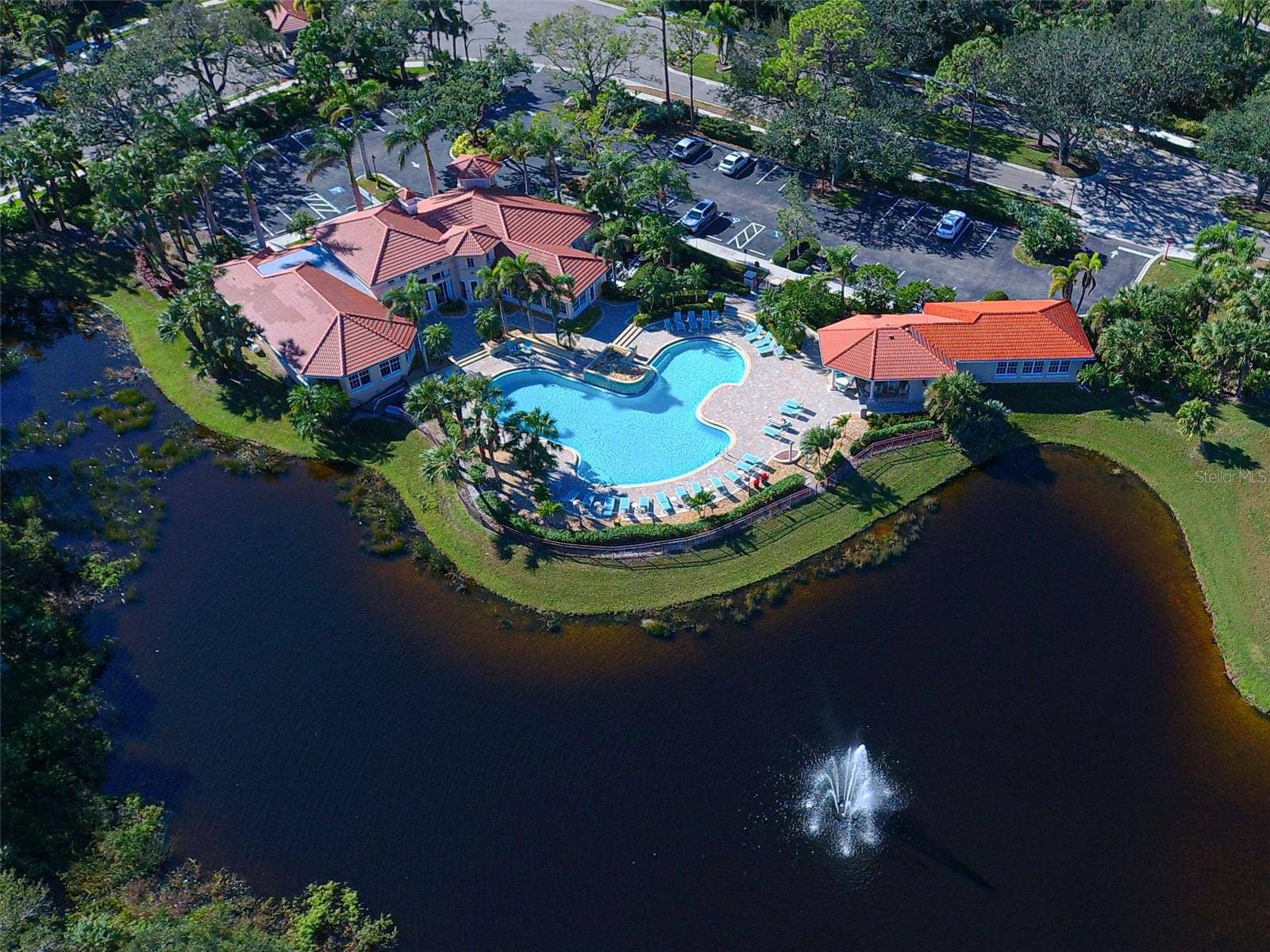 Bird's eye view of Sawgrass clubhouse, pool and fitness with lake, fountain and golf views.