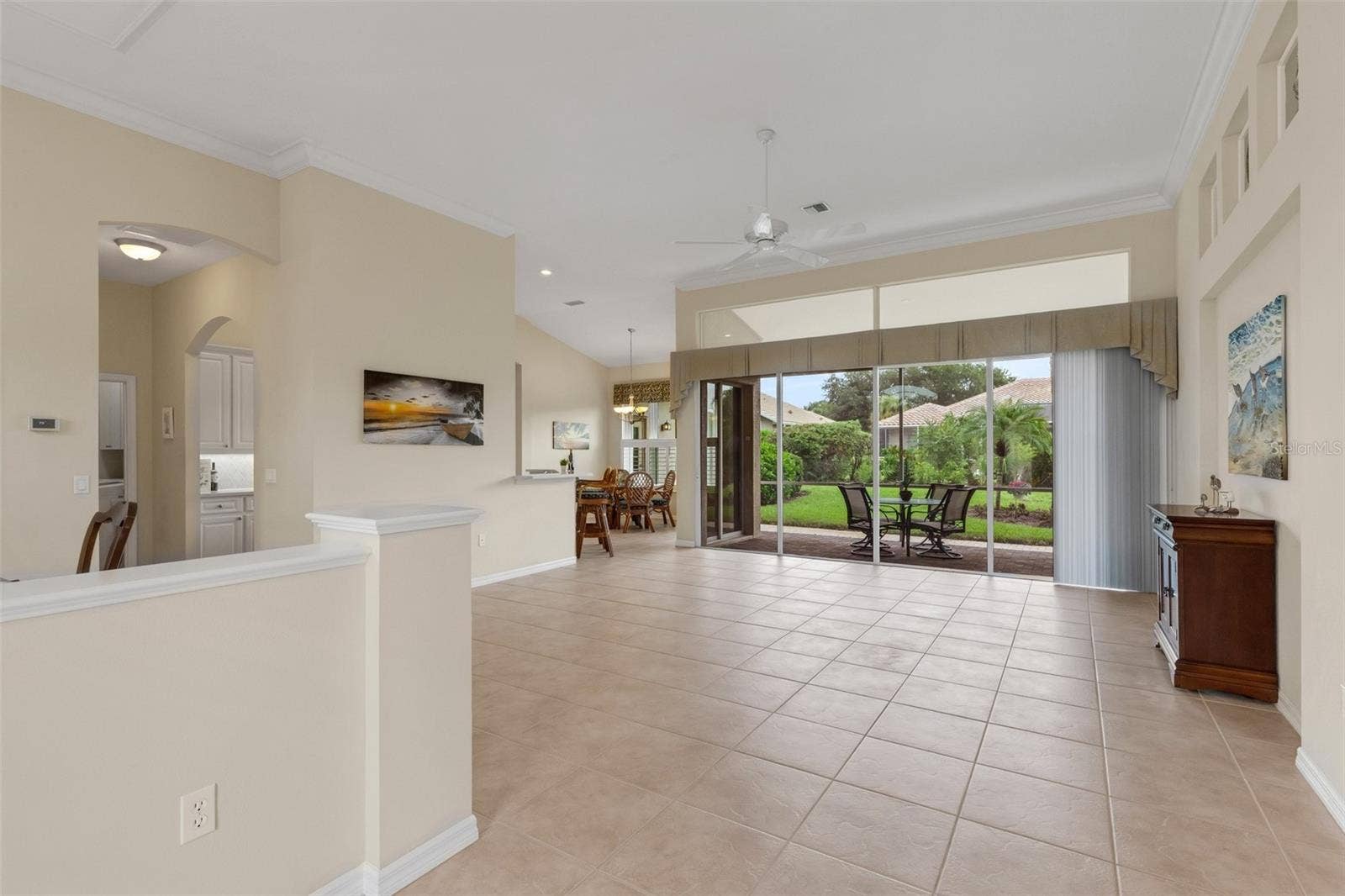 Spacious combination living room and dining  with wall of sliding glass doors that open to your screened lanai