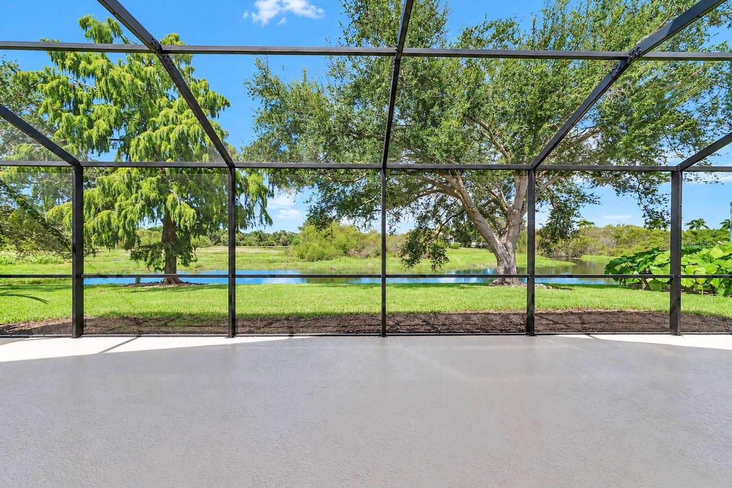 5113 FLAGSTONE DRIVE, Sarasota, FL 34238 Lake and nature preserve view from large extended lanai.