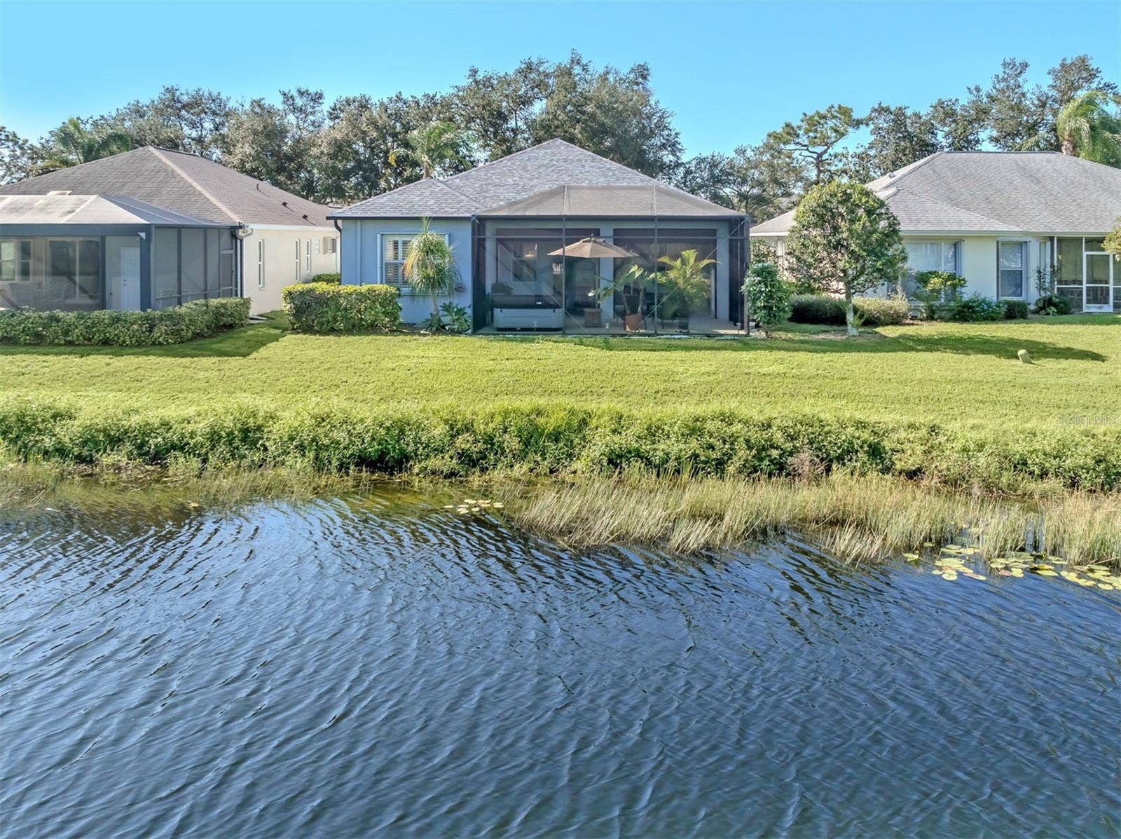 A lovely backyard setting with peaceful lake views, creating the perfect backdrop for relaxing and enjoying the beauty of Florida living!
