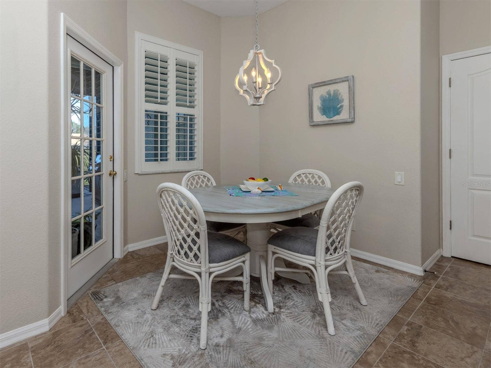 A charming breakfast nook with a delightful view! The perfect little spot to enjoy your morning coffee or a casual meal while overlooking the extended lanai and peaceful lake views beyond!