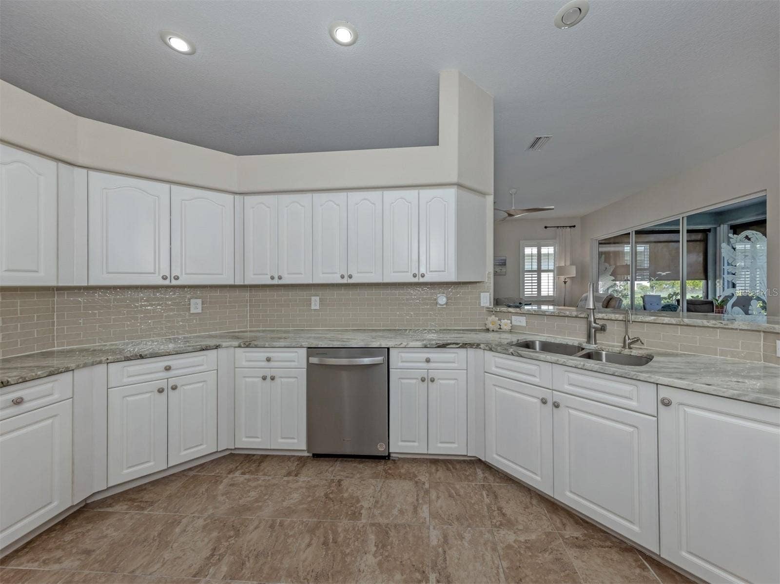 Crisp white cabinetry brings a fresh, timeless elegance to the kitchen, offering plenty of storage while beautifully complementing the rich granite countertops!