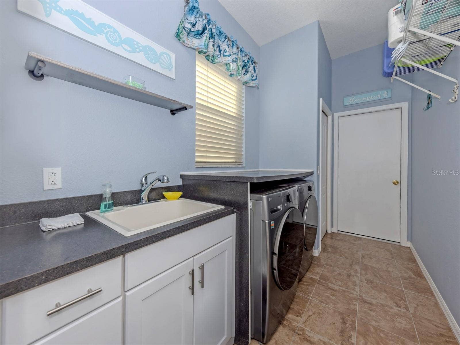 Even laundry day feels a little brighter in this wonderful, dedicated laundry room! Complete with a window for natural light, a convenient utility sink, and a storage closet, this practical yet inviting space keeps everything neatly tucked away, with direct access to the spacious two-car garage!