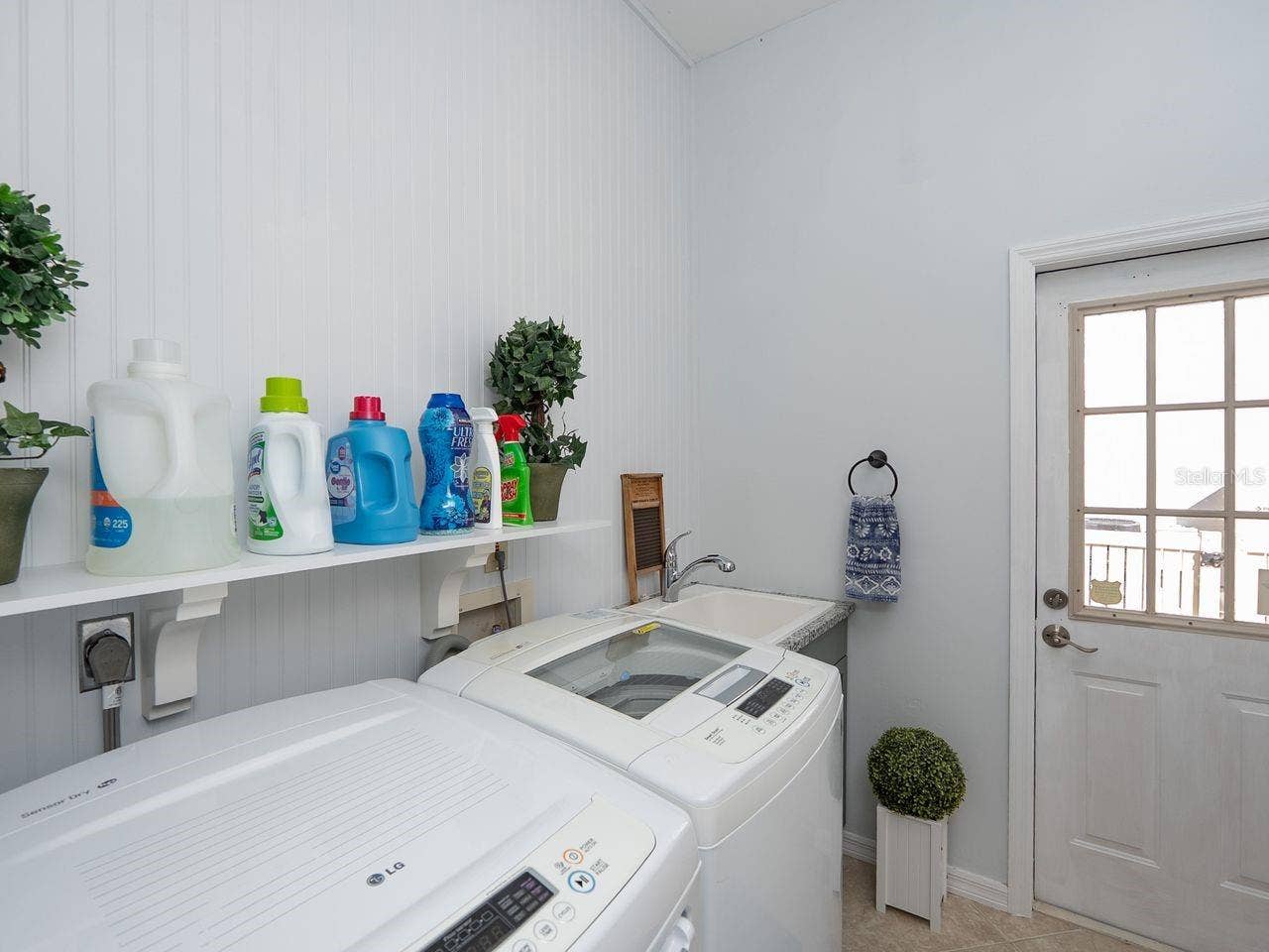 71 CAYMAN ISLES BOULEVARD, Englewood, FL 34223 inside laundry room with door to side of house by outside shower