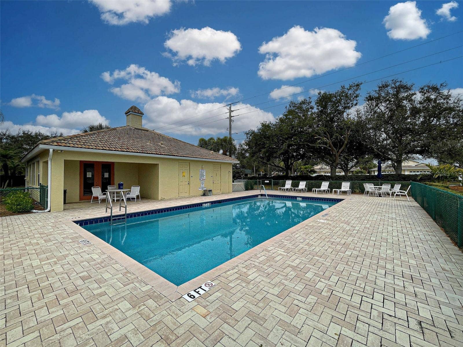 There is a large deck with pavers around the co9mmunity pool.