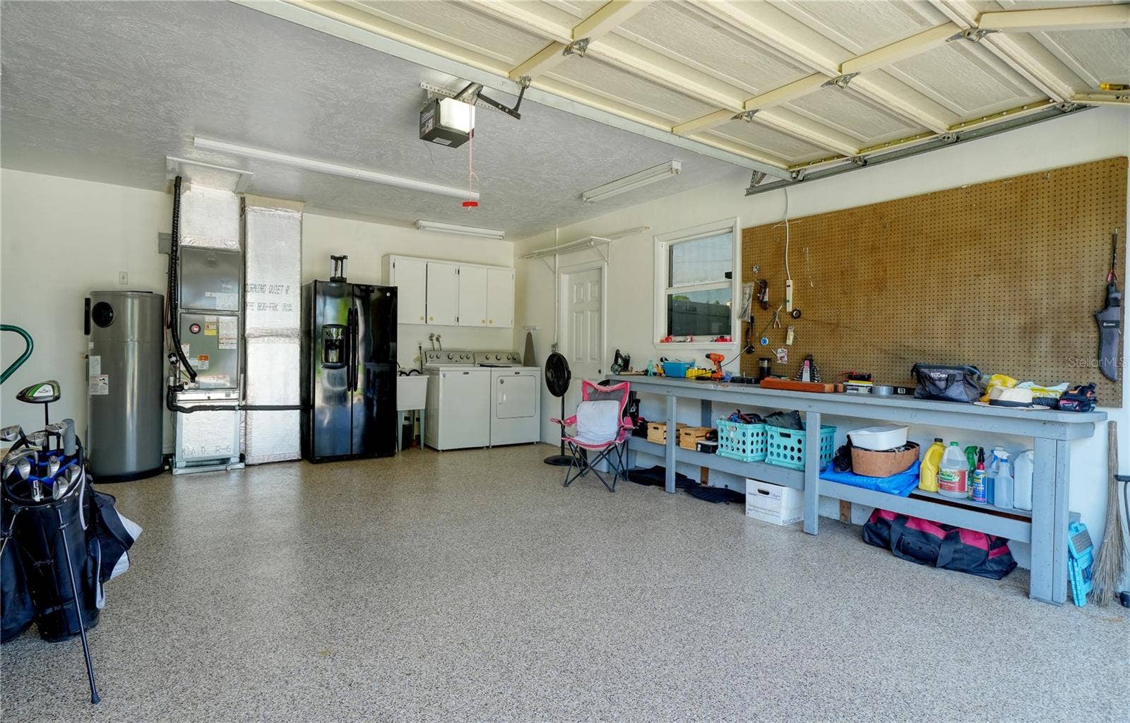 2304 50TH STREET W, Bradenton, FL 34209 Epoxy coated floor in 2 car garage, with laundry and second refrigerator and workbench - side door leads to RV/Boat trailer parking pad behind double door Vinyl fence
