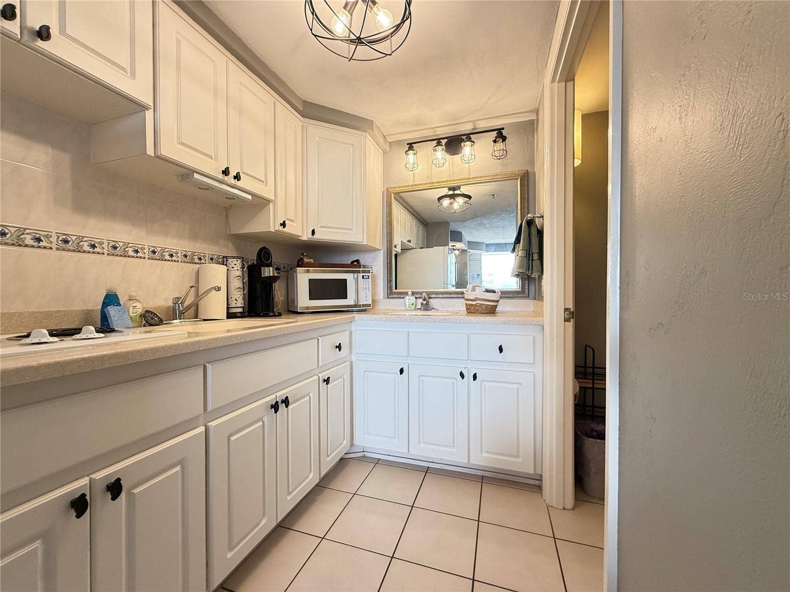 Kitchenette with stove top, microwave and a full size refrigerator.