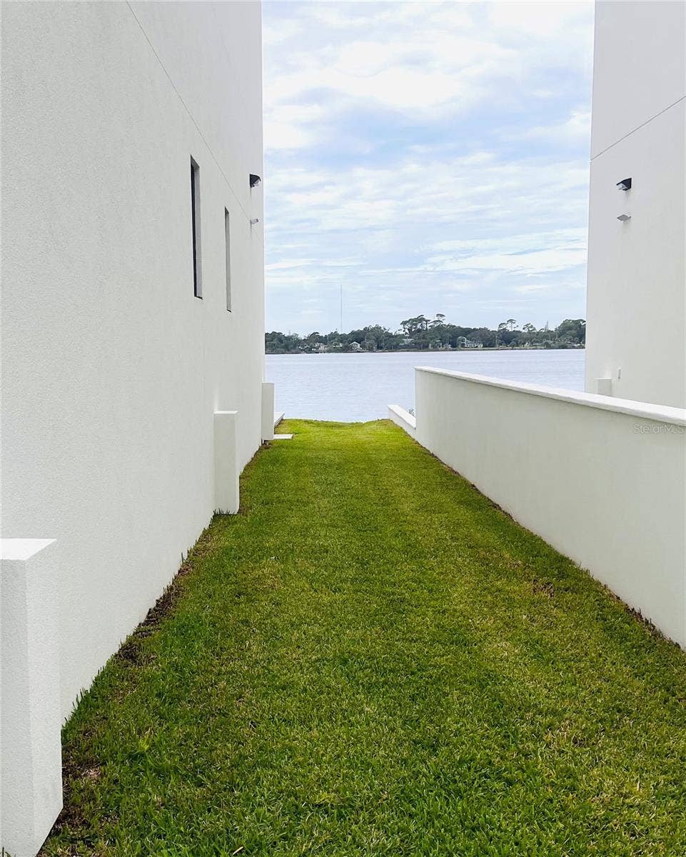 2115 N HALIFAX AVENUE, Daytona Beach, FL 32118 NORTH SIDE WITH SURROUNDING WALL