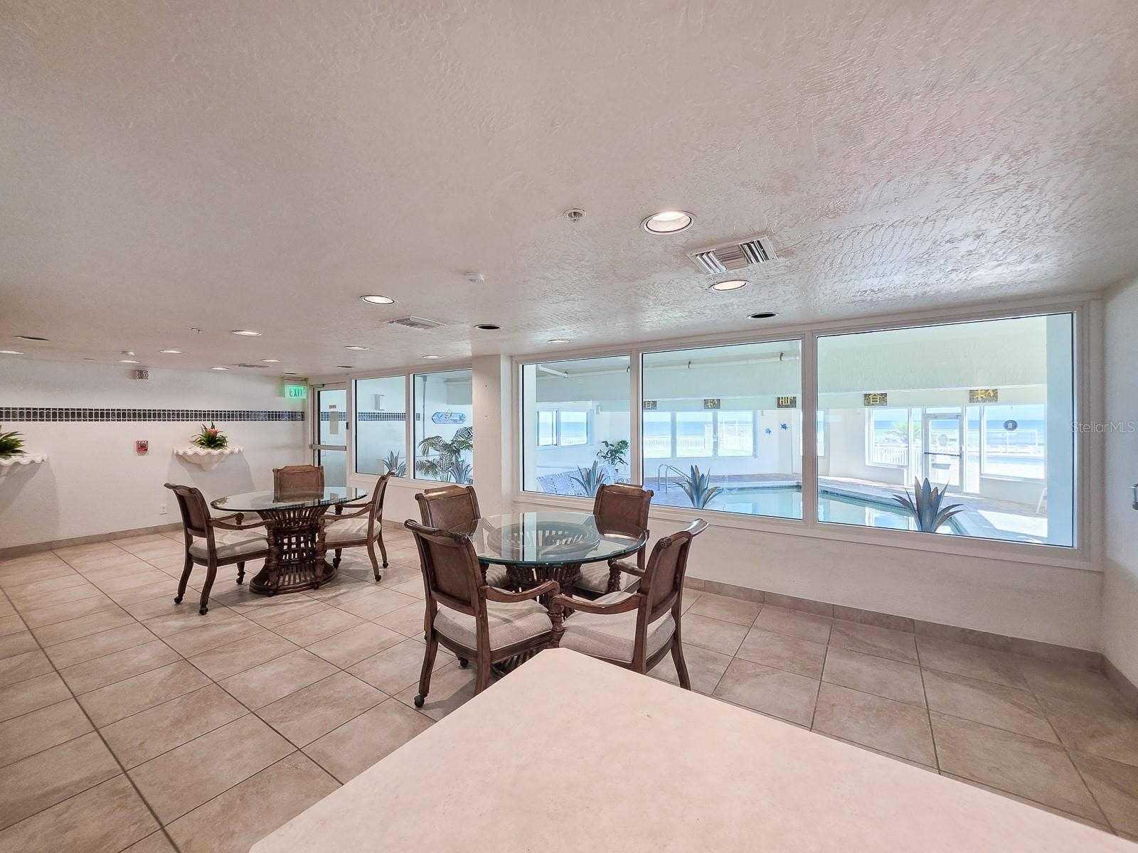2545 S ATLANTIC AVENUE, #403, Daytona Beach Shores, FL 32118 Community room with kitchen and view of the indoor heated pool
