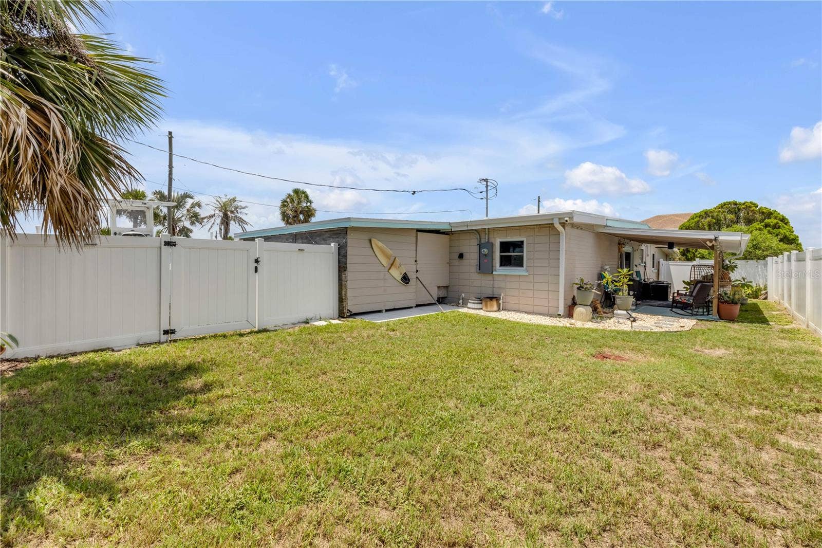 3929 S PENINSULA DRIVE, Port Orange, FL 32127 Rear exterior and fenced lawn.