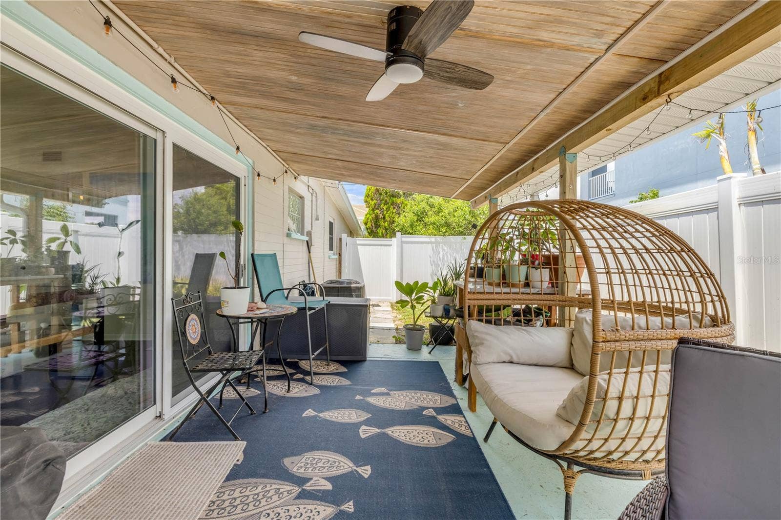3929 S PENINSULA DRIVE, Port Orange, FL 32127 Covered patio with outdoor seating and a hanging chair.