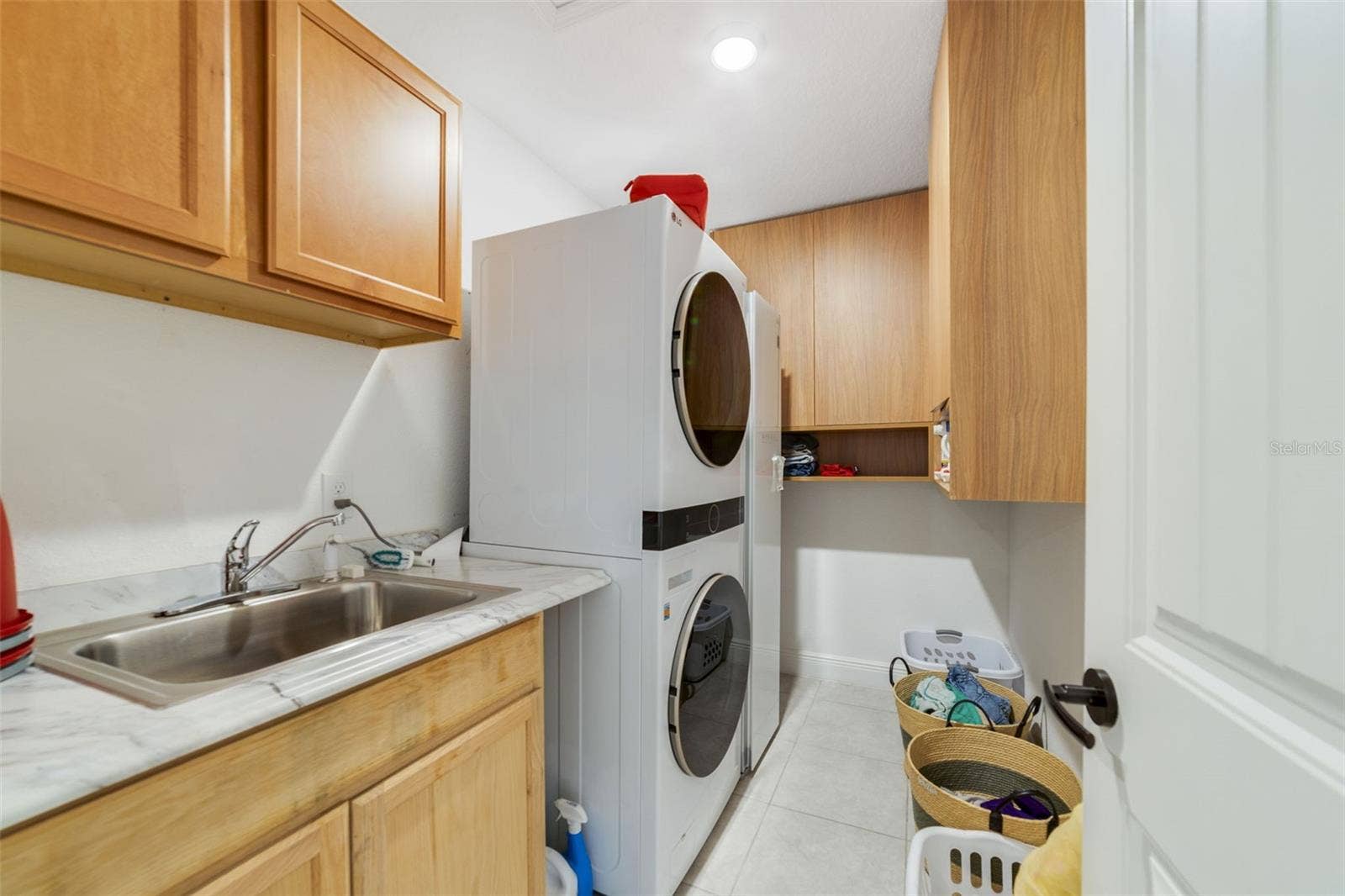 An upstairs Laundry room includes storage cabinets and a built-in sink, adding convenience and functionality.