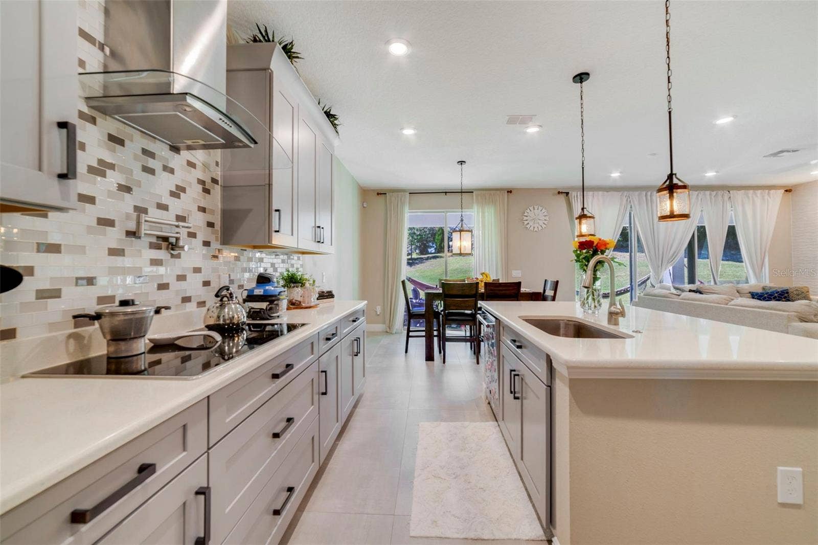 The DREAM KITCHEN is a showstopper with stylish cabinetry, stone countertops, a breakfast bar, built-in oven, cooktop stove with POT FILLER, tile backsplash, walk-in pantry, and a GALLEY-STYLE COFFEE BAR AREAperfect for morning routines or entertaining.