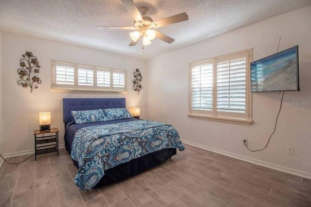 3120 PEEL AVENUE, Orlando, FL 32806 Master with queen bed, tv, side tables with lamp, ceiling fan, window to the outside.