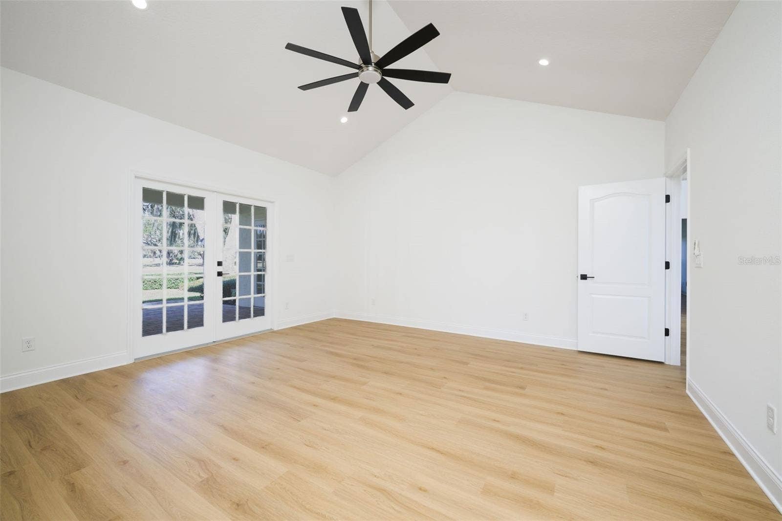 Primary Suite with French doors to covered lanai overlooking golf course.