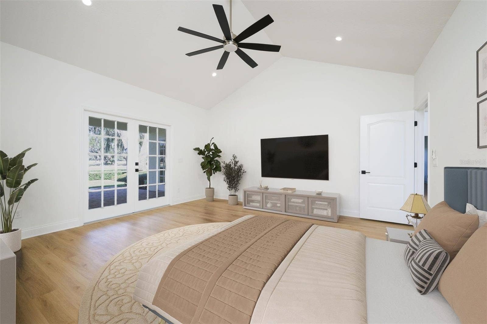 Primary Suite with French doors to covered lanai overlooking golf course.