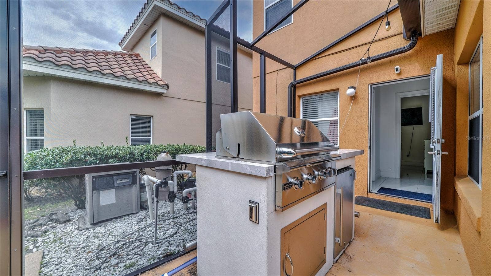 6956 LUCCA STREET, Orlando, FL 32819 Screened lanai featuring a built-in stainless steel grill.