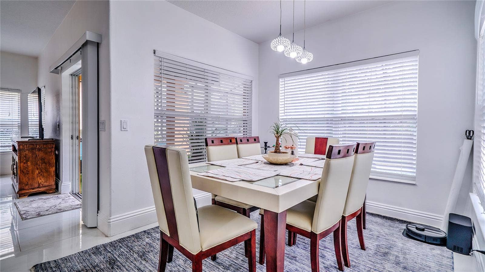 6956 LUCCA STREET, Orlando, FL 32819 Dining room connected to the kitchen with a view of the pool area.