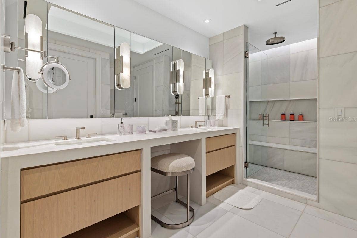 10160 AUTUMN MIST LANE, #402, Orlando, FL 32836 Luxurious primary bath featuring custom vanities, marble floors, walls and shower and lavish freestanding soaking tub.